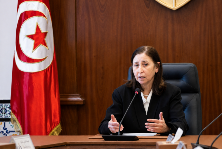 Sarra Zaafrani Zenzri s’exprime devant le drapeau tunisien.