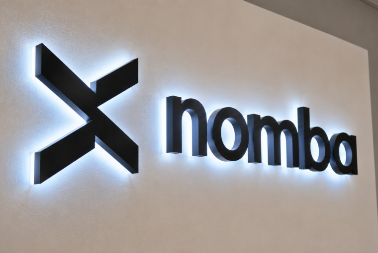 Logo lumineux de la fintech nigériane Nomba sur un mur.